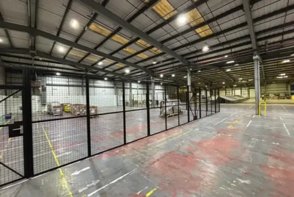 Run of steel mesh partitioning in a warehouse with double hinged doors for secure access