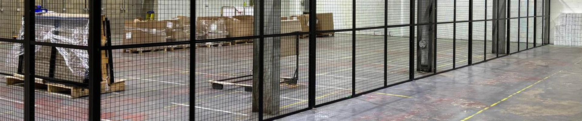 Standard height single skin mesh partition in a warehouse setting finished in black powder coating